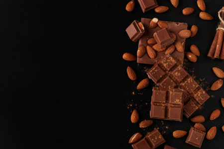 Chocolate with almonds and cinnamon on a dark background close-up, Copy space