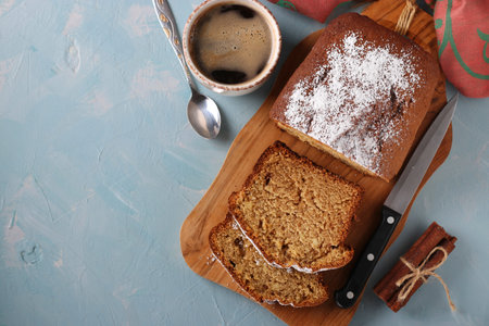 Homemade coffee muffin on a wooden board and a cup of coffee on a light blue background, copy space,...
