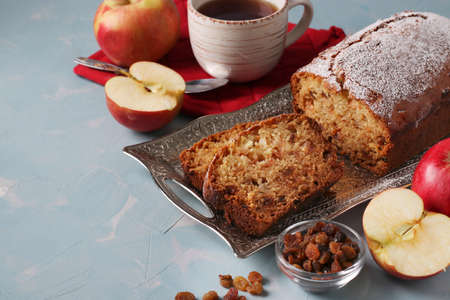 Homemade muffin with semolina, apples and raisins on a metal tray on a light blue background, close-up, Copy spaceの写真素材