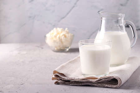 Kefir or Ayran fermented drink in a glass and jug, as well as cottage cheese in a bowl on light gray background, Copy space, Closeupの写真素材