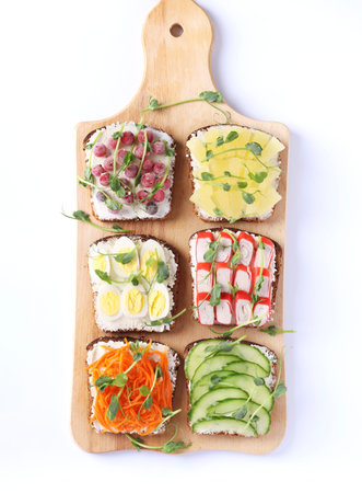 Six sandwiches on toast with fresh carrots, cucumbers, pineapple, red currant, crab sticks and quail...