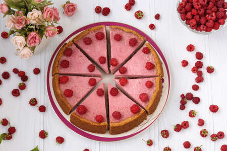 Homemade raspberry cheesecake cut in portions on a plate, located on white background, Closeup, Horizontal formatの写真素材