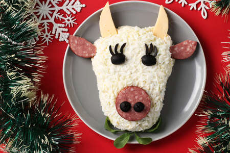 Festive Bull-shaped salad for 2021 on red background, Symbolic food for new year, Top view, Horizontal formatの写真素材