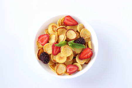 Trendy tiny pancakes for breakfast with strawberry, blackberry and mint in bowl on white background,...