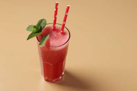Watermelon cocktail with mint on beige background with place for textの写真素材