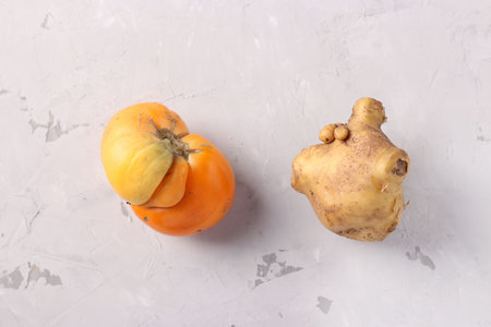 Ugly tomato and potato on light gray background, Closeup, Ugly food consept, Top view
