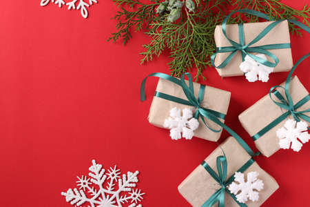 Christmas giftboxs with green ribbon on red surface. Space for wishes. Holiday card. Top view. Space for textの写真素材