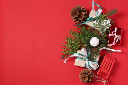 Christmas composition of holiday gifts and decor on red background. Boxing day. Greeting card. Happy New Year. Flat lay. Space for textの写真素材