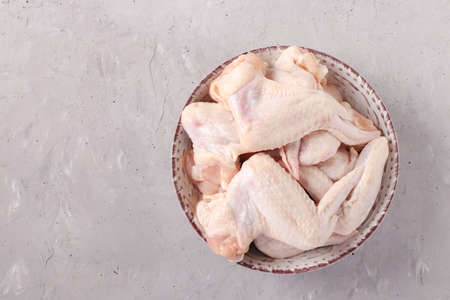 Raw chicken wings in a plate on light gray background, Top view, Horizontal format, Space for textの写真素材