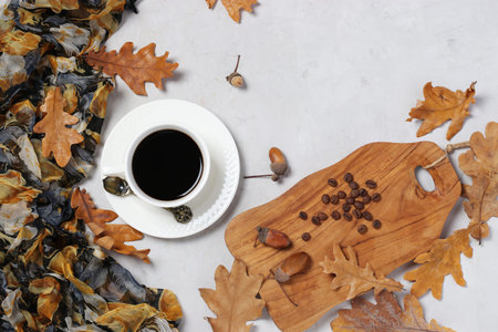 Acorn coffee with fall oak leaves on gray background. Coffee substitute without caffeine. Top view