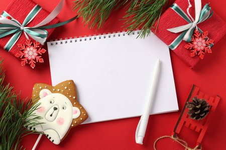 Christmas checklist or empty blank letter for Santa Claus with gingerbread and gifts on red. Top...