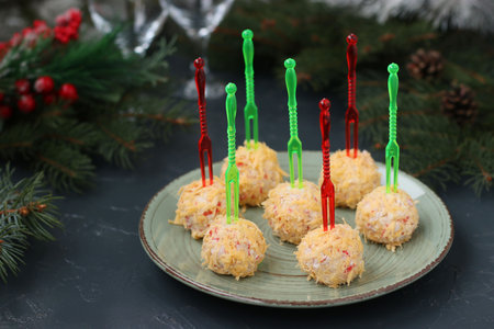 Balls of crab sticks and cheese in cheese shavings on dark background. Festive snack for Christmas and New Year.の写真素材