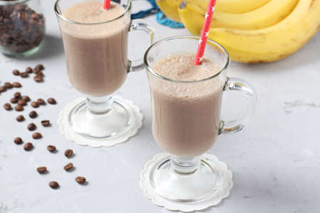 Banana latte with spices in two glass on gray background. Horizontal format.の写真素材