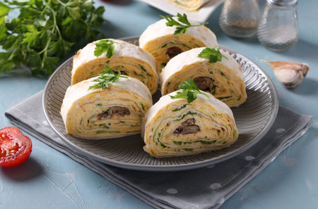 Lavash roll with sprats, cream cheese, cucumber and eggs on a light blue background. Close-upの写真素材