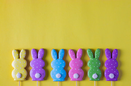 Easter colorful gingerbreads in the form of cute rabbits on yellow background. Easter concept. View...