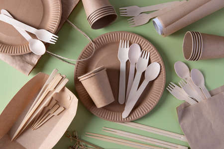Disposable biodegradable tableware on craft paper plates - forks, spoons, glasses, wooden and bamboo skewers, sushi sticks, parchment. Zero Waste. View from aboveの写真素材