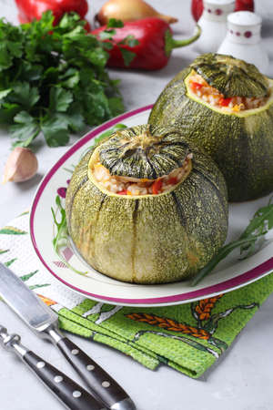 Zucchini stuffed with rice and vegetables on light background. Vegetarian food. Vertical formatの写真素材