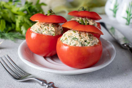 Stuffed tomatoes with cheese, dill and garlic on white plate on a light background. Close-upの写真素材