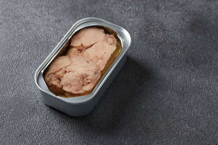 Cod liver in an iron jar on dark gray background. Space for text. Horizontal formatの写真素材