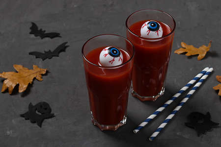 Eyes in glass with tomato cocktail on dark gray table for Autumn Holiday Halloween.の写真素材