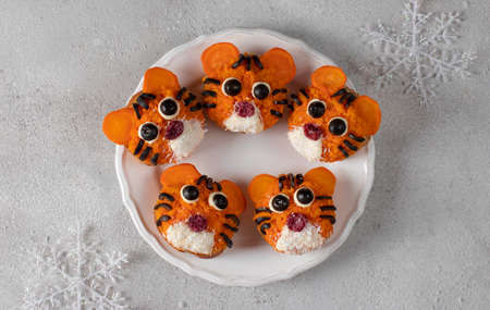 Tiger Sandwiches for New Year 2022 of carrot and black olives on white bread on gray background, culinary idea for children, top viewの写真素材
