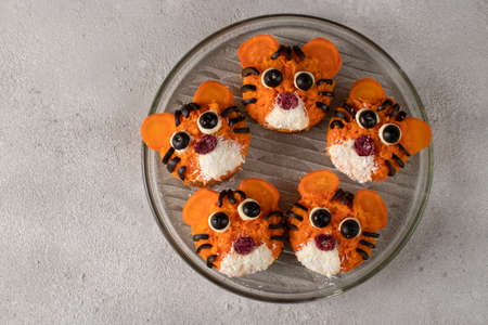 Tiger Sandwiches for New Year 2022 of carrot and black olives on white bread on gray background, culinary idea for childrenの写真素材