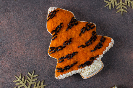 Salad in shaped christmas tree of carrots and black olives on a brown background. Cooking idea for...