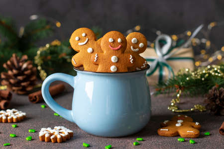 Homemade gingerbread cookies in the form of fabulous gingerbread men and christmas trees in blue cup in new year composition, Close-upの写真素材