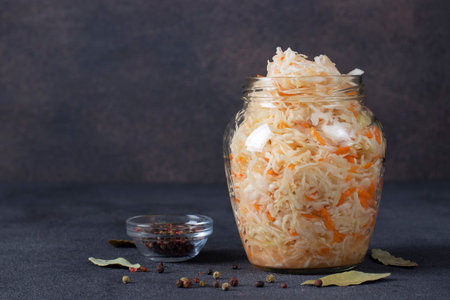 Homemade Sauerkraut with carrots in glass jar on gray background, Fermented food, Copy spaceの写真素材