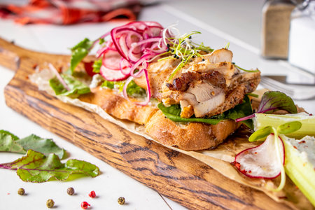 Bruschetta with chicken, radish, microgreens and red onion on wooden boardの写真素材