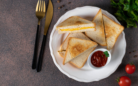 Sandwiches with egg and cheese fried in pan served with tomato sauce for breakfast, Top view