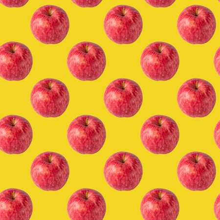 seamless pattern with red apple on the bright yellow background for wallpaper or wrapping-paper, autumn harvestの写真素材