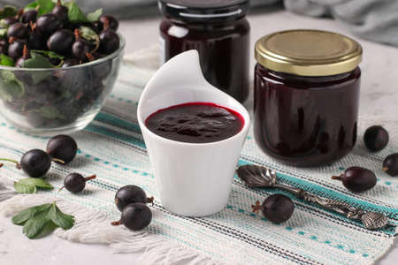Homemade thick yoshta jam, in bowl and glass jars on light gray backgroundの写真素材