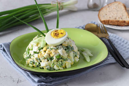 Salad with egg and green onions dressed with mayonnaise on plate on gray backgroundの写真素材