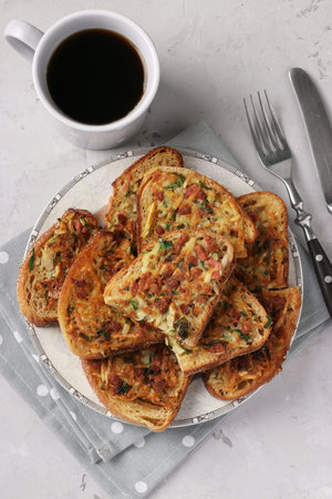 Hot sandwiches with potatoes and sausage in a plate and cup of coffee on gray table, Top view