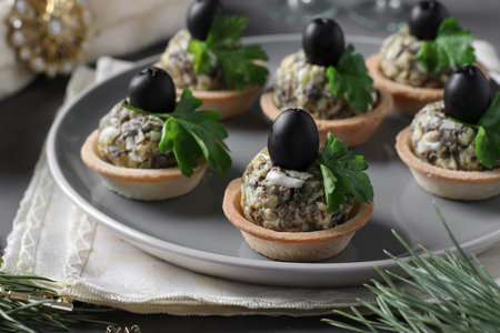 Tartlets with mushrooms, egg and black olives on gray background, Close-upの写真素材