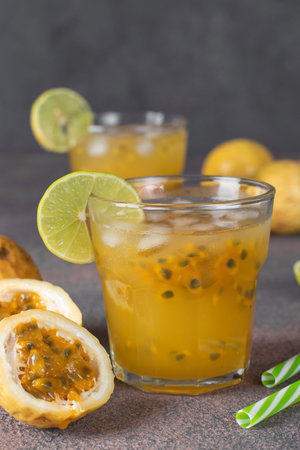 Tropical fresh juice mango, passion fruit and lime in two glasses on dark backgroundの写真素材