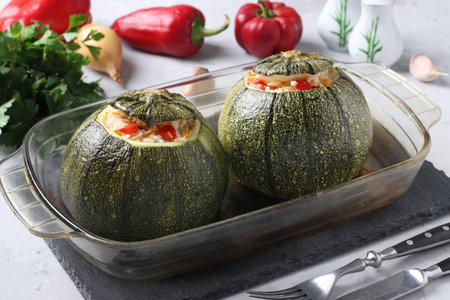 Baked zucchini stuffed with rice and vegetables in a ceramic form on a gray table, Vegetarian foodの写真素材