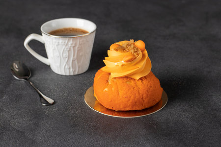 French Shu Cake - tasty profiterole with sweet shortcrust crust, mango, custard and cup of coffee on...