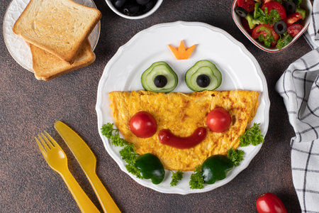 Breakfast idea for kids - frog princees shaped of omelette with vegetables, View from aboveの写真素材