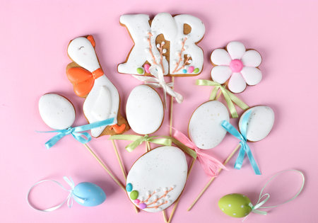 Easter gingerbread cookies in the shape of eggs on pink background. Easter greeting card. Top view