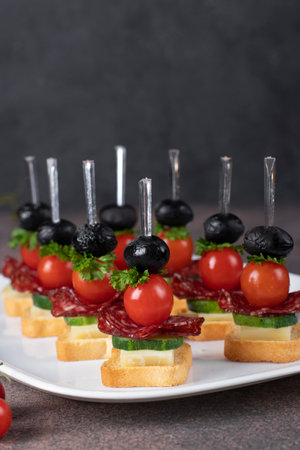 Canape with cherry tomatoes, sausage, cheese and black olivesの写真素材