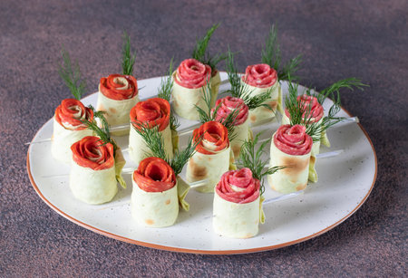 Lavash roses with cream cheese, sausage chorizo and salami on white plate. Appetizer for Valentines Day, Mothers Day or birthdayの写真素材