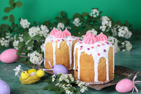 Easter cakes on green background with pink and lilac eggs. Spring church holiday concept