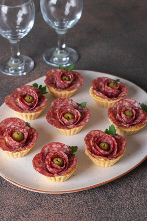Tartlets in shape of roses with sausage salami and olives, festive snackの写真素材