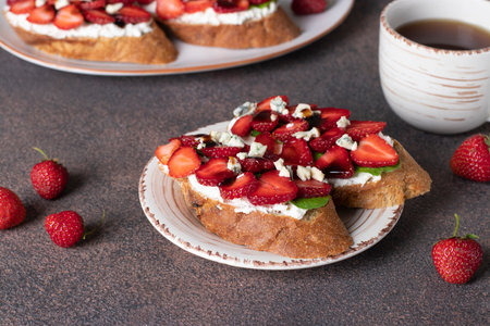 Bruschetta with strawberries, arugula and dor bleu cheese for breakfastの写真素材