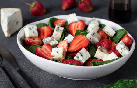 Healthy salad with strawberries, spinach and cheese dor blue, dressed with balsamicの写真素材
