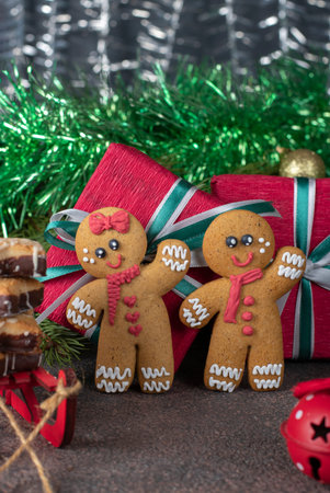 Cookies Gingerbread man and red paper gift on festive new year background. Homemade sweet pastries...
