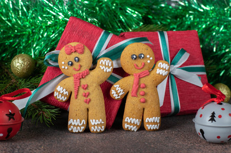 Cookies Gingerbread man and red paper gift on festive new year background. Homemade sweet pastries...