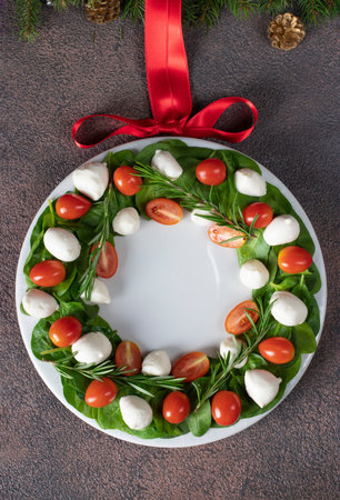 Salad Caprese with cherry tomatoes, spinach and mini mozzarella shape Christmas wreath, Top viewの写真素材